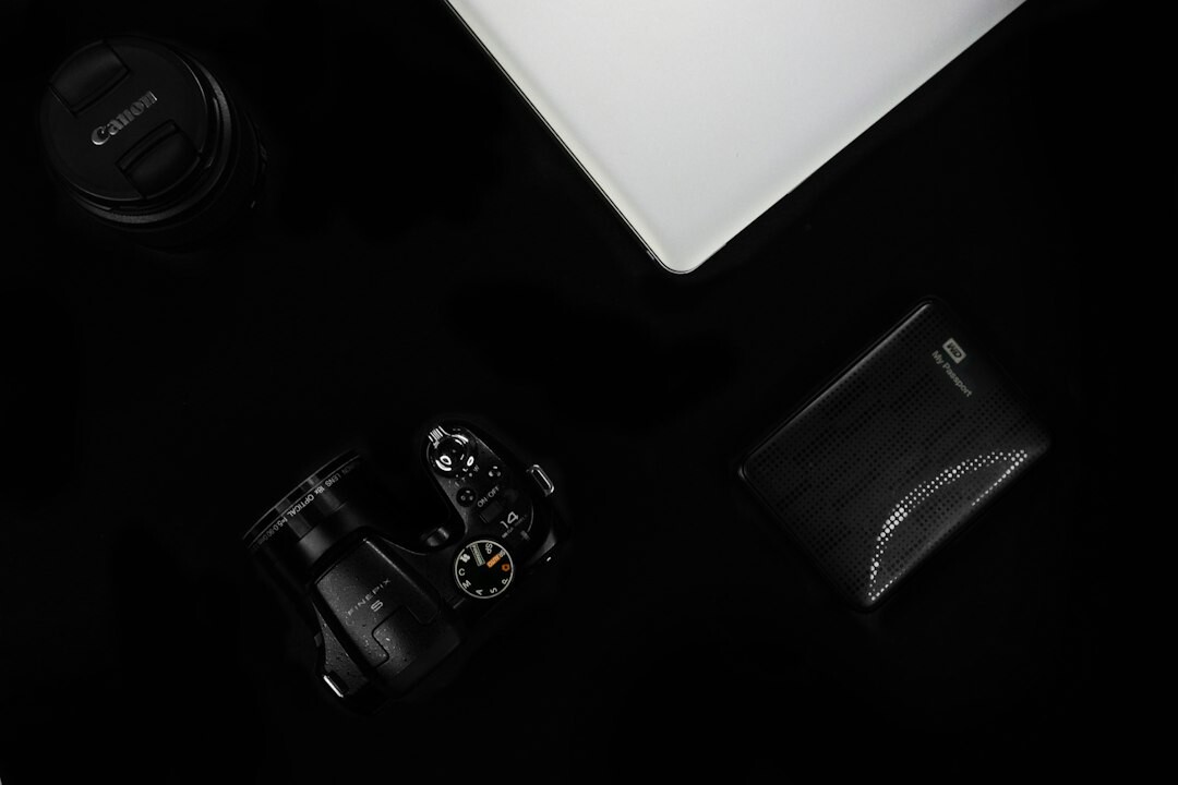 Top-down view of a photographer's desk with camera, film rolls and notebook